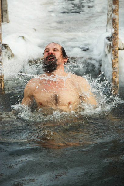 istock A middle-aged man is immersed in an ice hole. 926334788