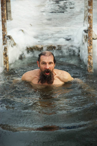 istock A middle-aged man is immersed in an ice hole. 926334802