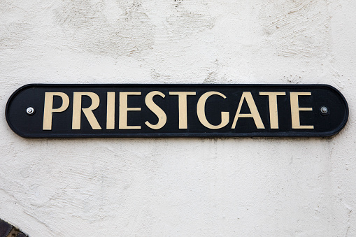 A street sign for Priestgate in the cathedral city of Peterborough in Cambridgeshire, UK.