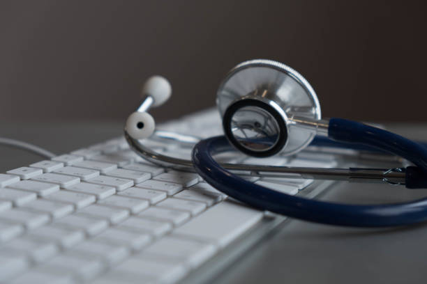 istock Silver stethoscope lying down on an laptop, toned blue 926347926