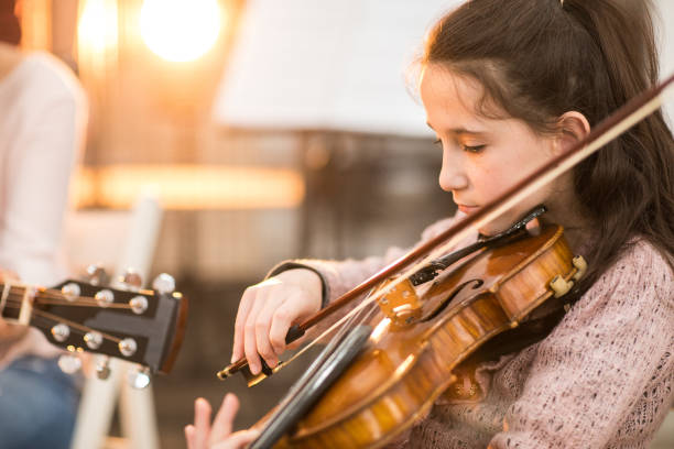 istock Little girl playing the violin 926350336