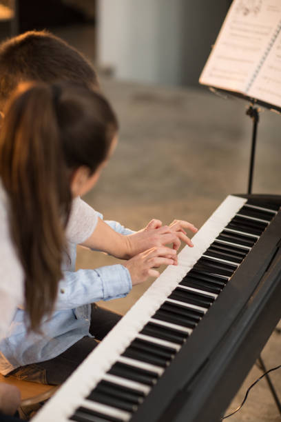 istock Young boy playing piano at music school 926358560
