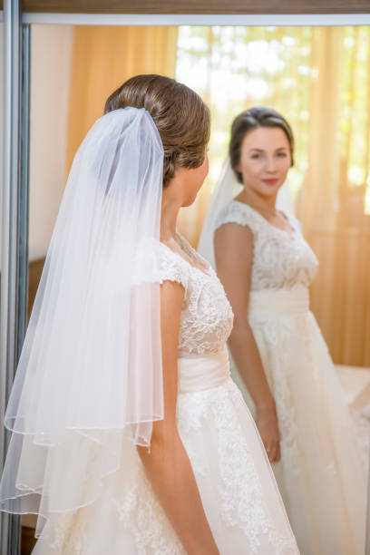 istock Bride in wedding dress looking in the mirror 926359526