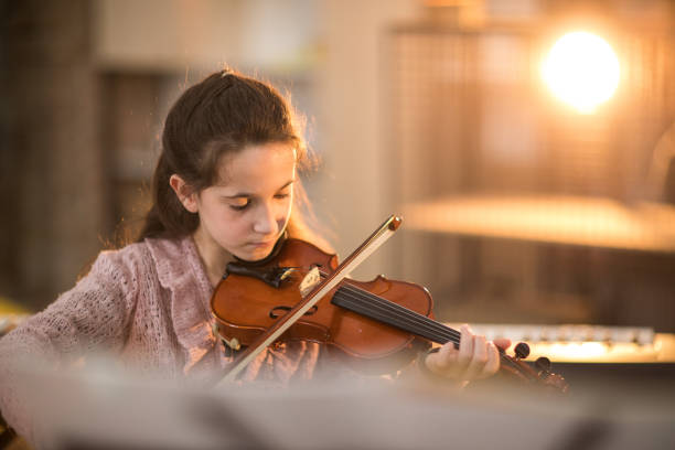 istock Little girl playing the violin 926365540