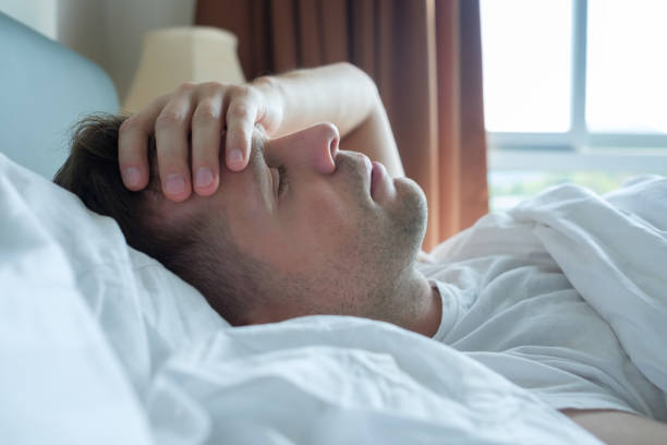 istock man lying in bed at home suffering from headache or hangover 926365932
