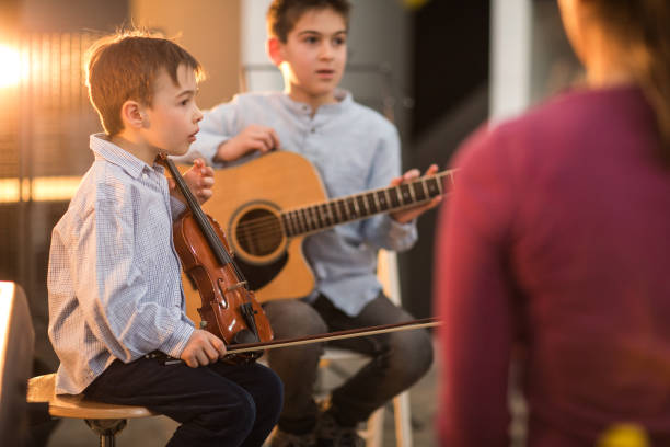 istock Boys at the music class playing together 926373416