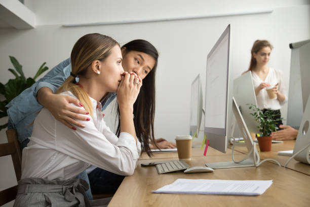 Asian colleague supporting caucasian coworker reading bad news in email Asian colleague embracing supporting caucasian woman reading bad news in email, teammate comforting stressed frustrated female coworker upset by dismissal, helping to solve problem online in office fired employee stock pictures, royalty-free photos & images