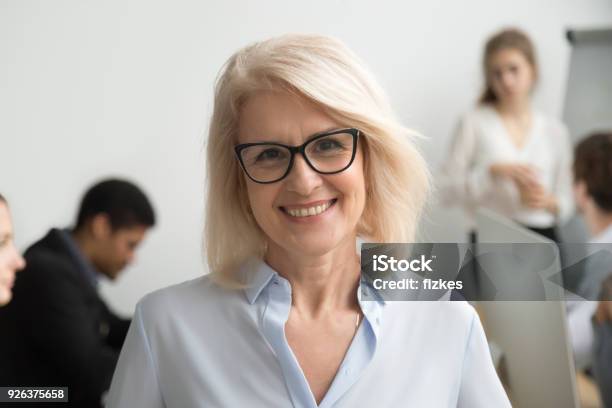 Photo libre de droit de Souriant Porter Portrait De Verres Hauts Femme Daffaires Avec Les Gens Daffaires À Fond banque d'images et plus d'images libres de droit de Femmes