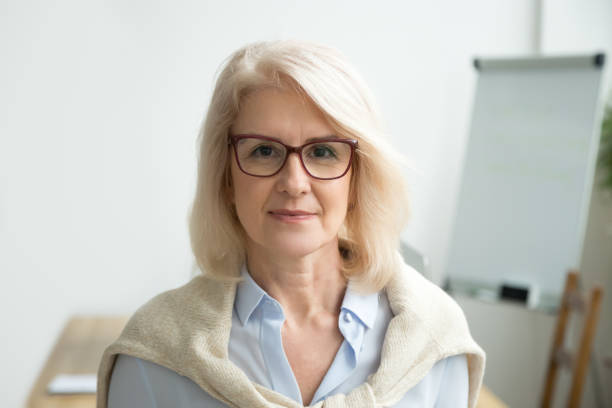 confident d’ans femme lunettes caméra, tête en regardant - women professor mature adult human face photos et images de collection