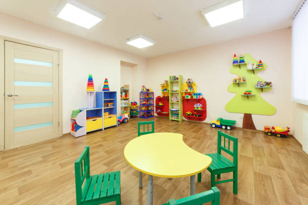 istock Yellow table for classes with children and light pink colored game room with in the kindergarten 926378998