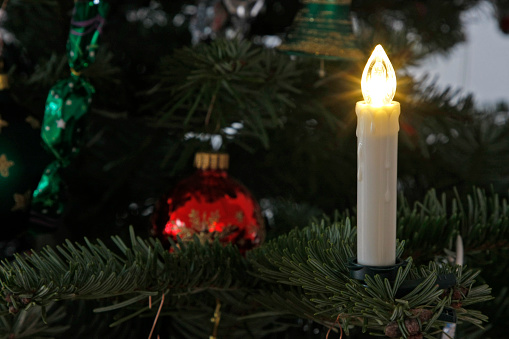 christmas burning candle over on decorative candlestick