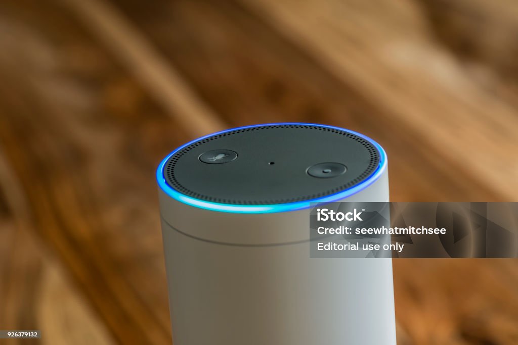 Amazon Echo, the voice recognition streaming device from Amazon MUENSTER - JANUARY 27, 2018: White Amazon Echo Plus, Alexa Voice Service activated recognition system photographed on wooden table in living room. Amazon Echo Stock Photo