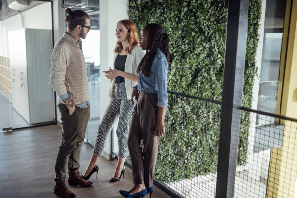 istock Team of three discussing new ideas in hallway 926379340