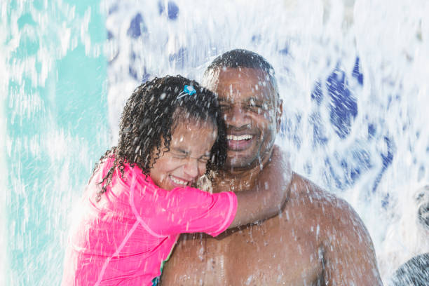 Father and daughter at water park getting splashed