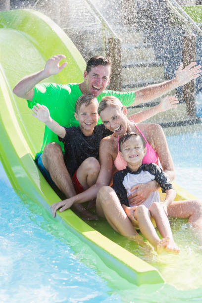 istock Family with two boys on waterslide at a water park 926392992