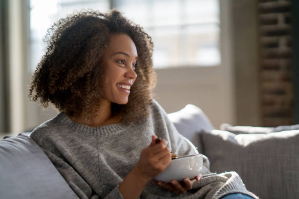 woman at home eating cereals for breakfast - eating women breakfast cereal imagens e fotografias de stock