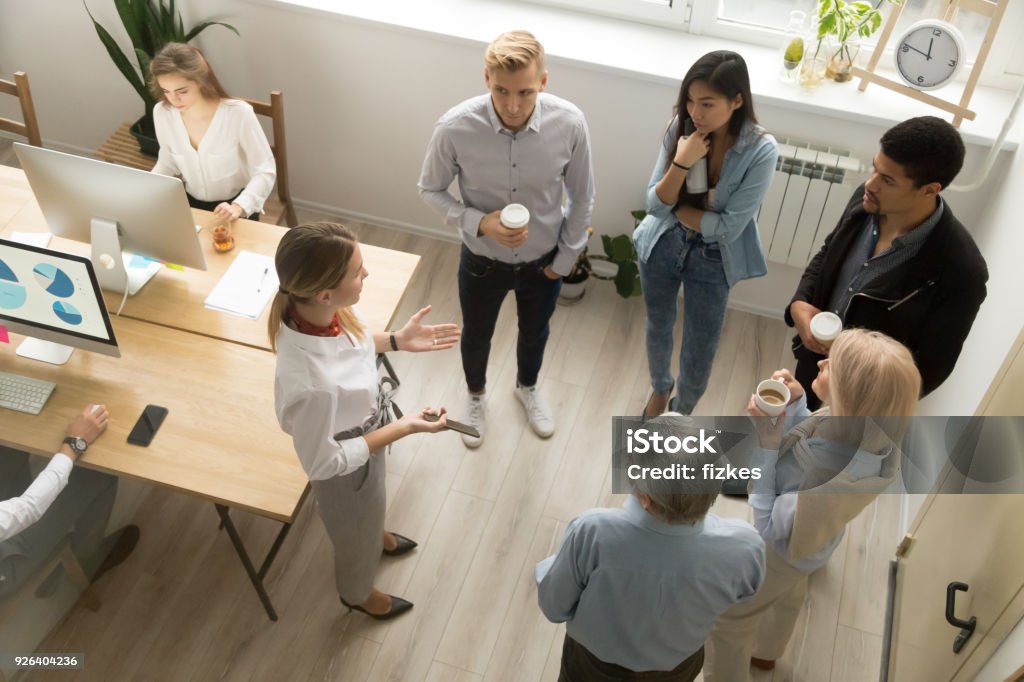 Team leaders meet multiracial interns in coworking office, top view Team leaders meet multiracial interns in office explaining new job, company executives talking to diverse workers listening instructions at break, discussion and computer work in coworking, top view Guidance Stock Photo