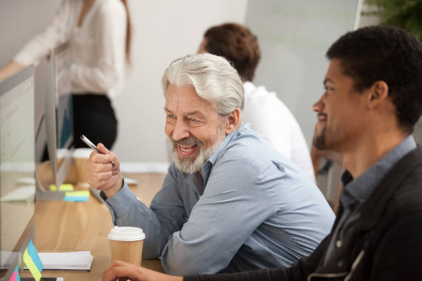 istock Smiling senior employee discussing email with african colleague at workplace 926404312