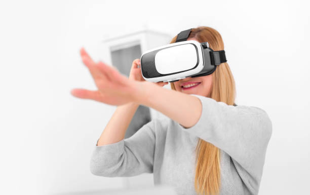 Beautiful young woman playing game in virtual reality glasses