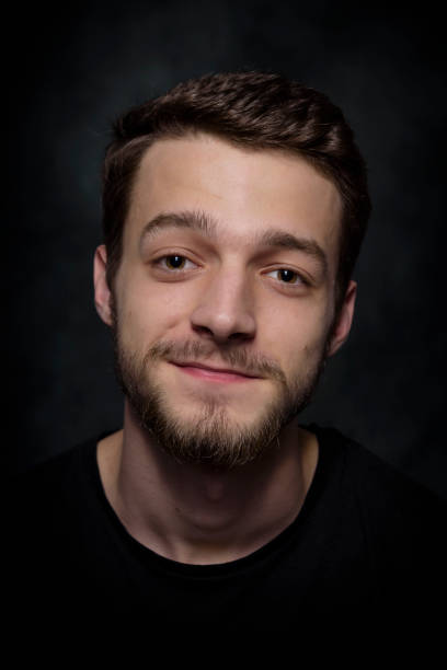 istock Portrait of a young man with a beard on a dark background 926420520