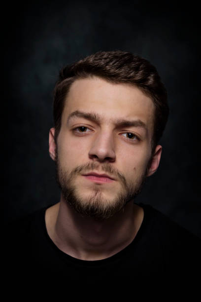 istock Portrait of a young man with a beard on a dark background 926420544