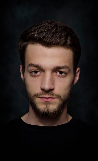 istock Portrait of a young man with a beard on a dark background 926420576