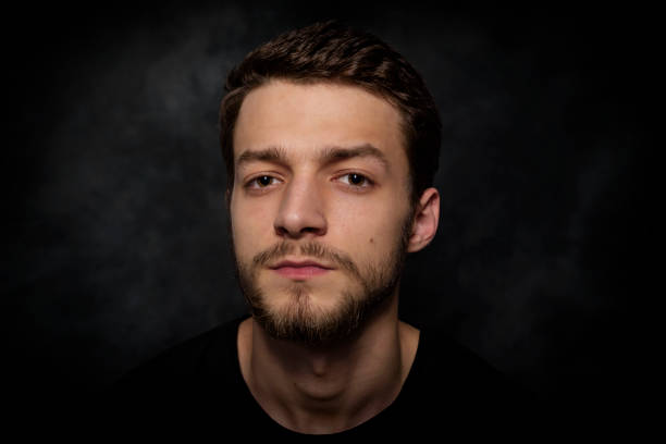 istock Portrait of a young man with a beard on a dark background 926420602
