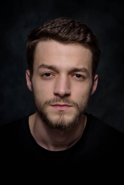 istock Portrait of a young man with a beard on a dark background 926421392