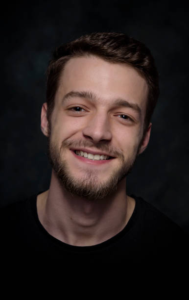 istock Portrait of a young man with a beard on a dark background 926421400