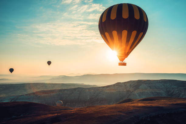 Hot air balloons flying over the valley at Cappadocia, Turkey Hot air balloons flying over the valley at Cappadocia, Turkey. dramatic landscape photos stock pictures, royalty-free photos & images