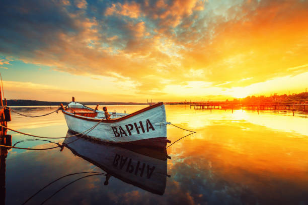 Fishing Boat on Varna lake with a reflection in the water at sunset. stock photo