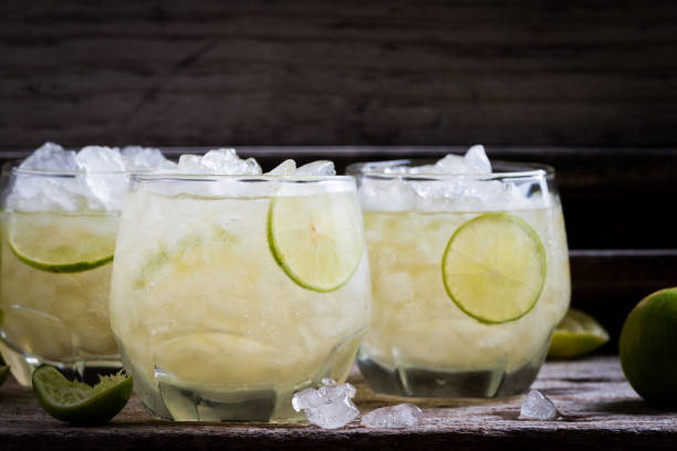 istock Cocktail with ice and lime slice on old wood table 926436124