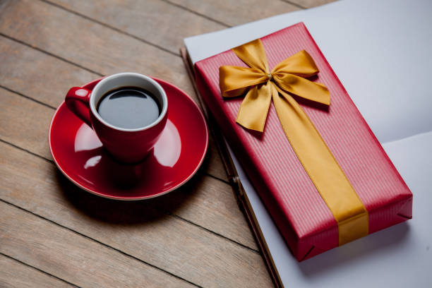istock Cup of coffee with gift box on wooden background 926436482