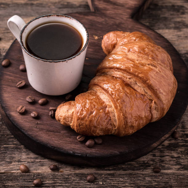istock Breakfast with coffee and croissants on wooden vintage table 926441424