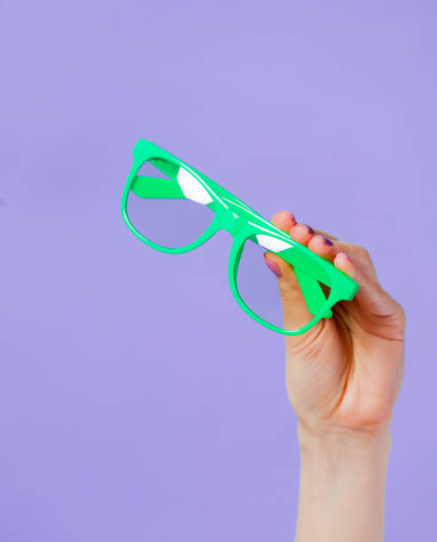 istock Female hand holding green eyeglasses 926444148