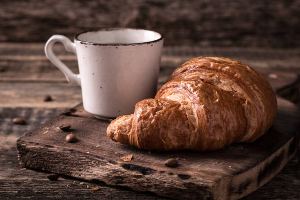 istock Breakfast with coffee and croissants on wooden vintage table 926444990