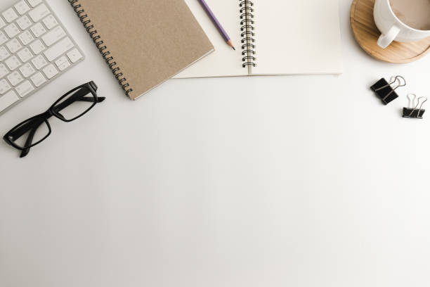 istock White office desk table with blank notebook, computer, supplies and coffee cup. Top view with copy space. Flat lay. 926454858