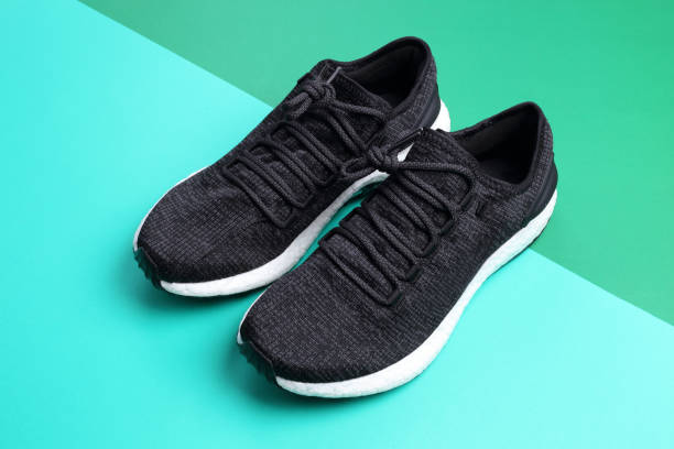 istock Black sneakers on dark green and light green diagonal background 926461660