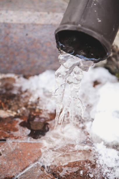 istock Icicles of original form hang on edge of  pipe 926468282