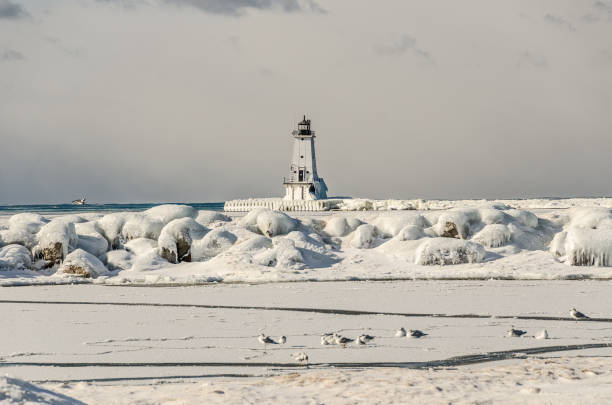 istock Sunlit Snow on Rocks at North Breakwater Light 926475412
