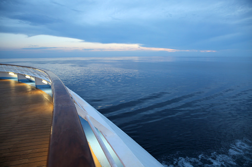 Twlight over a cruise ship deck, sailing across the calm ocean.