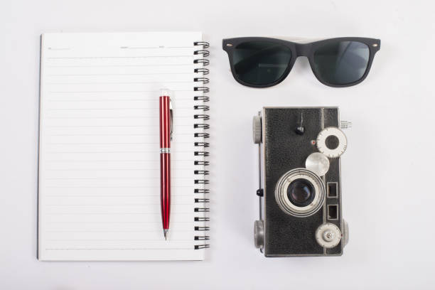 istock Sunglasses and vintage camera with notepad isolated on a white background. 926486154