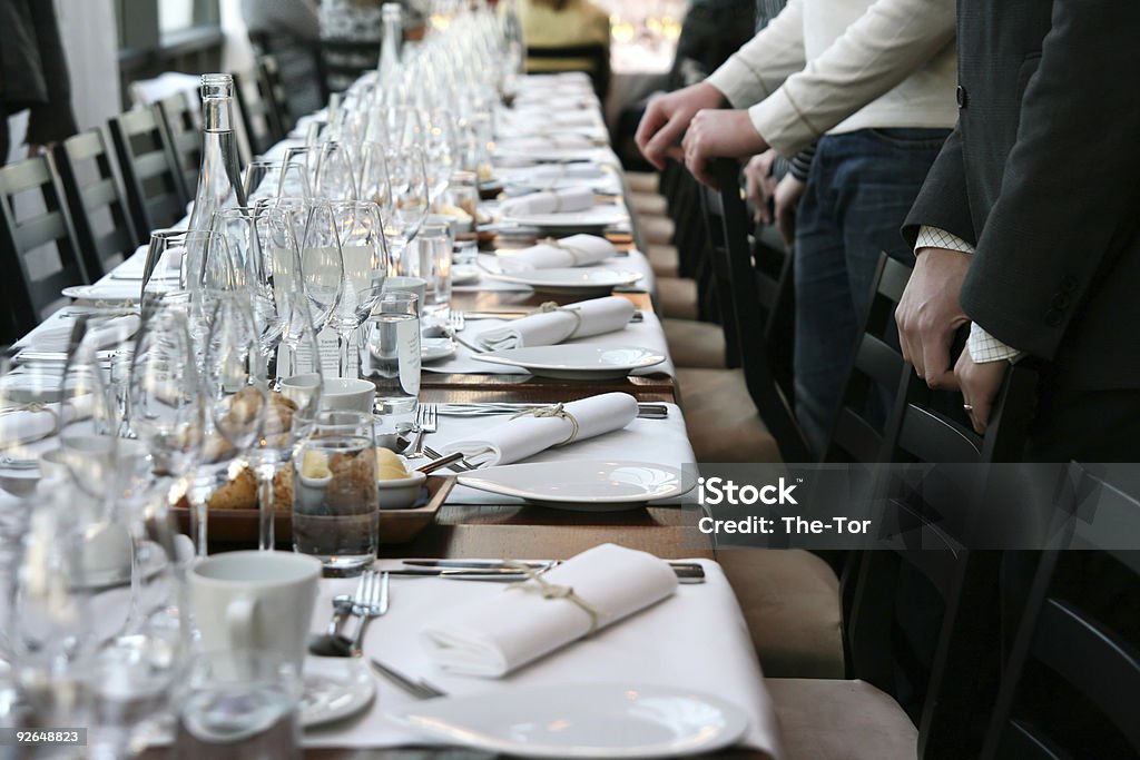 Guests in front of table set for dinner People waiting for the dinner to start. Banquet Stock Photo