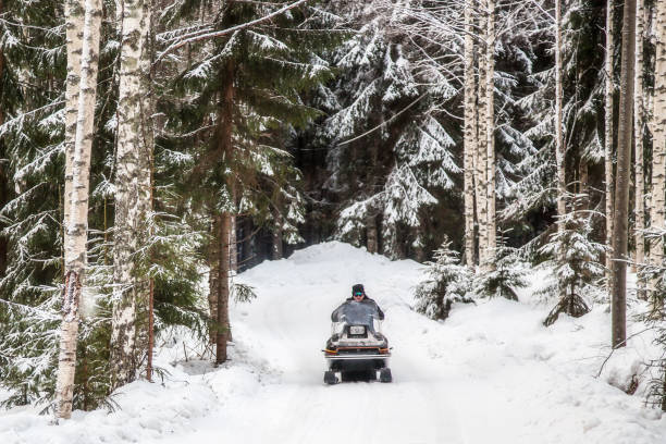 istock A man is riding a snowmobile in the winter forest 926490496