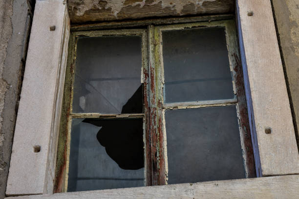 istock A broken window on an old house. Dirty gray, damaged wall. 926497368