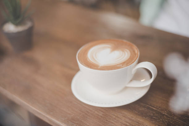 istock Hot art latte coffee with heart shape in a cup on wooden table. 926498968