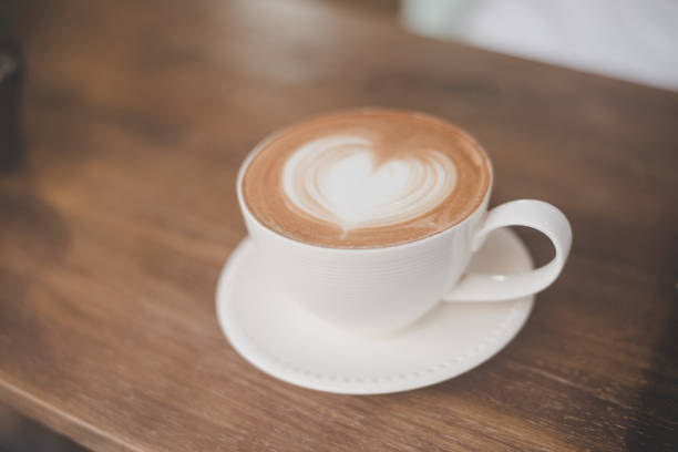 istock Hot art latte coffee with heart shape in a cup on wooden table. 926500698