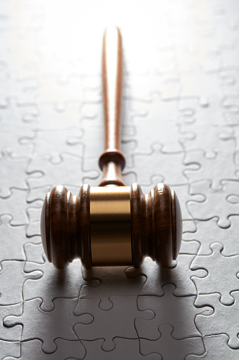 Gavel on a jigsaw puzzle with back lighting