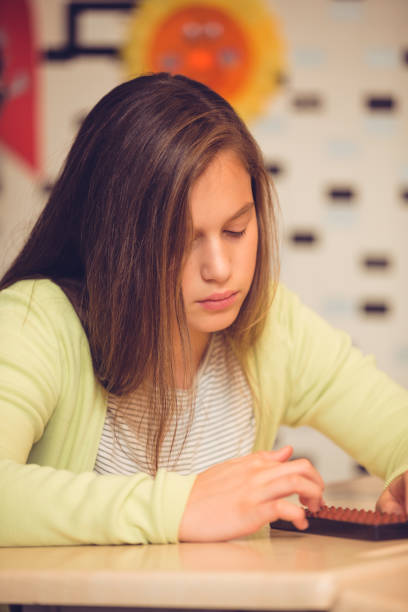 istock Schoolgirl in classroom with abacus 926506630