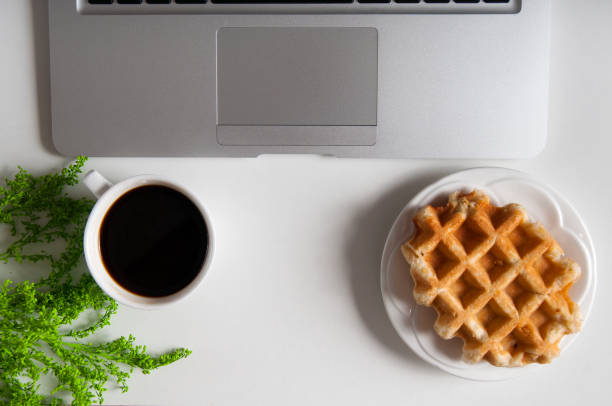 istock Notebook with hot coffee with wafer on wood table 926506716